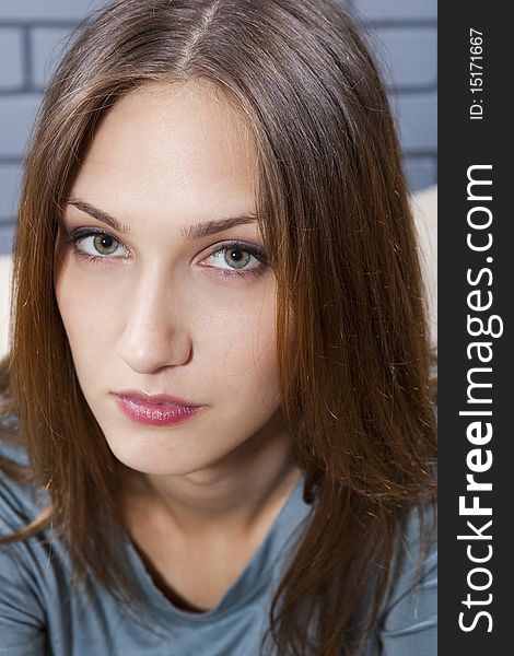 Young female portrait against grey brick wall