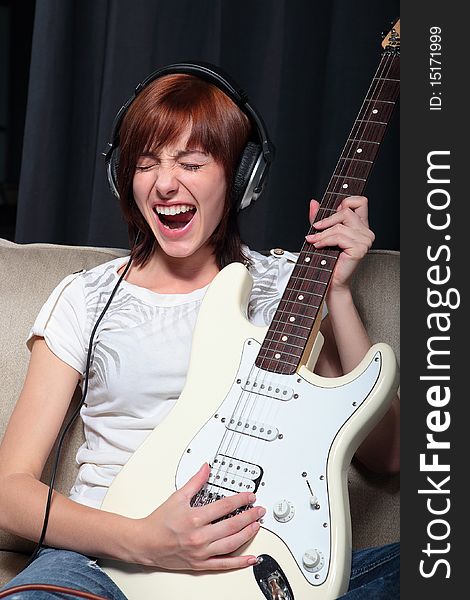 Young woman playing electric guitar