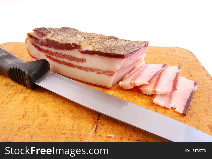 Knife with slices of bacon on a chopping board