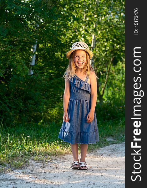 Laughing beautiful girl stand at the rural road in the jeans dress. Laughing beautiful girl stand at the rural road in the jeans dress.