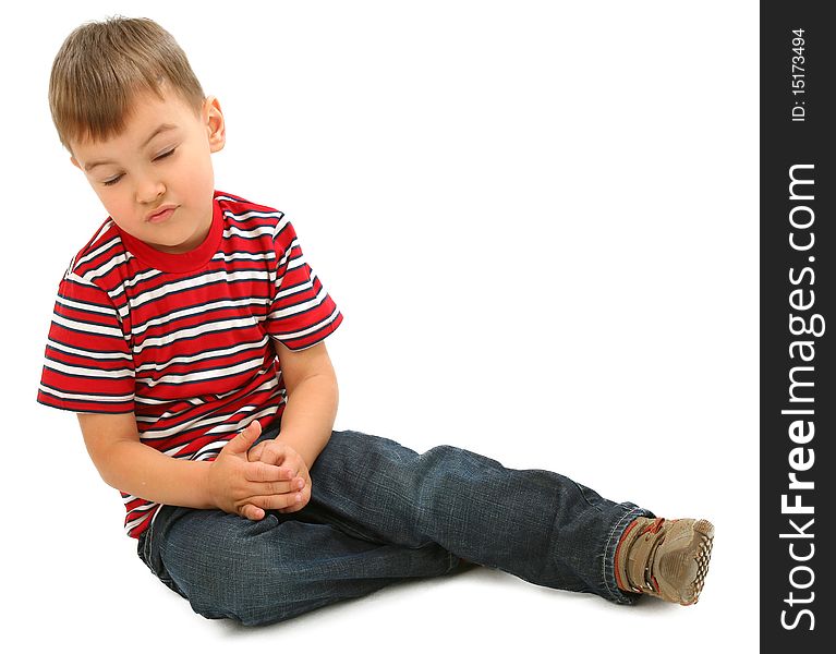 Little boy sitting on floor with closed eyes against white background