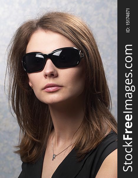 Young woman with black glasses over light defocused background. Young woman with black glasses over light defocused background
