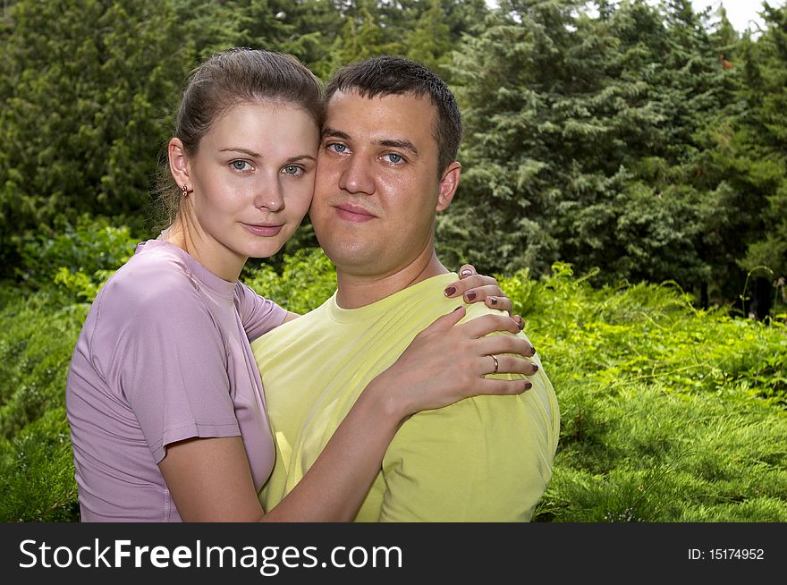Young couple in the park over defocused background