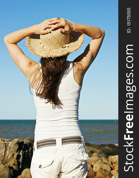 Beautiful young woman relaxing by the ocean