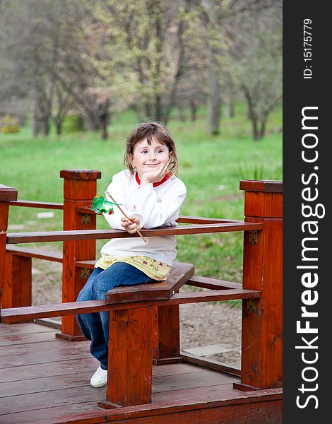 Little girl sitting in the park in spring with a happy expression. Little girl sitting in the park in spring with a happy expression.