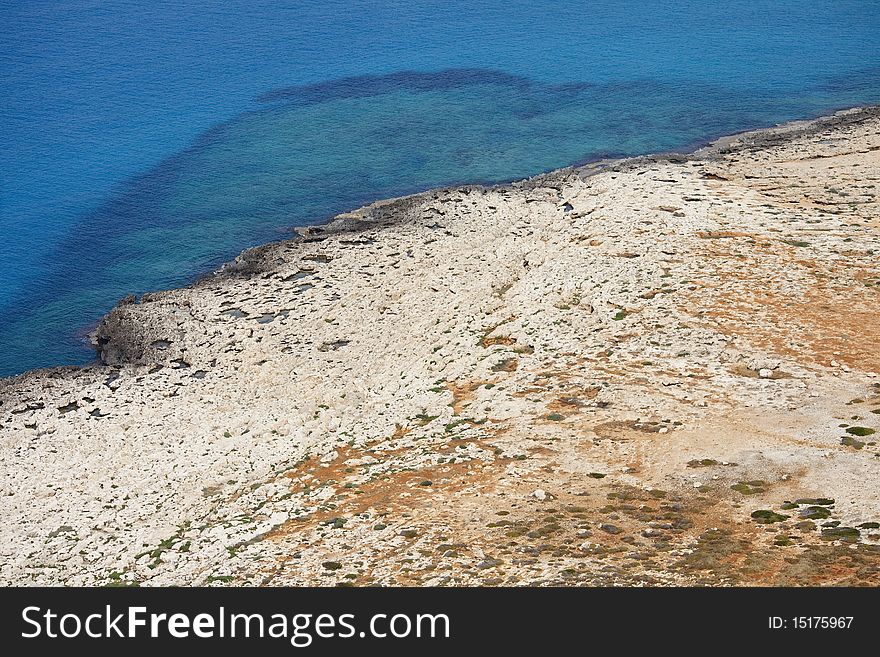 Shoreline of rocky desert at the foot of the mountain at the Cape El Greco, Cyprus. Shoreline of rocky desert at the foot of the mountain at the Cape El Greco, Cyprus