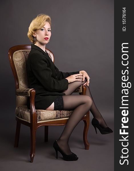 Woman In A Business Suit Sits In An Armchair
