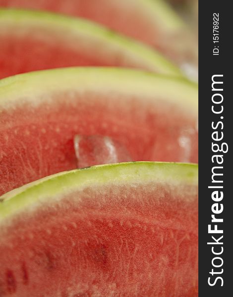 Stack of watermelon slices kept cool in ice at summer market. Stack of watermelon slices kept cool in ice at summer market