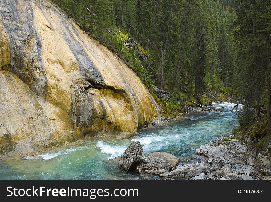 Flowing River next to red rock in Jognson Canyon, Banff National Park, Alberta, Canada