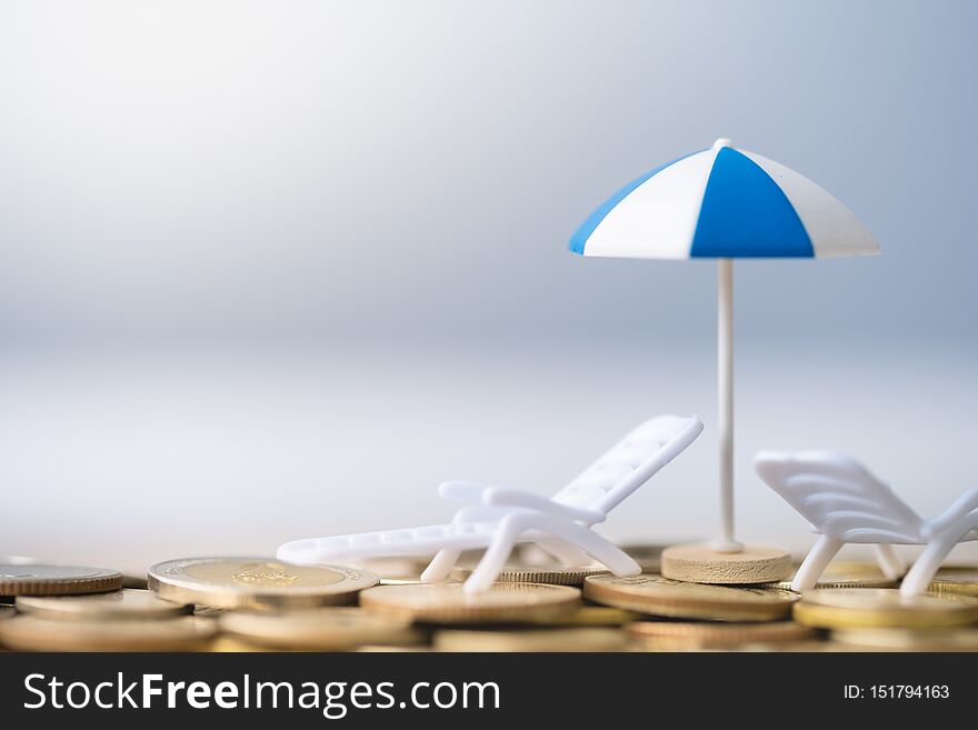 Umbrella and chair on coins stack.