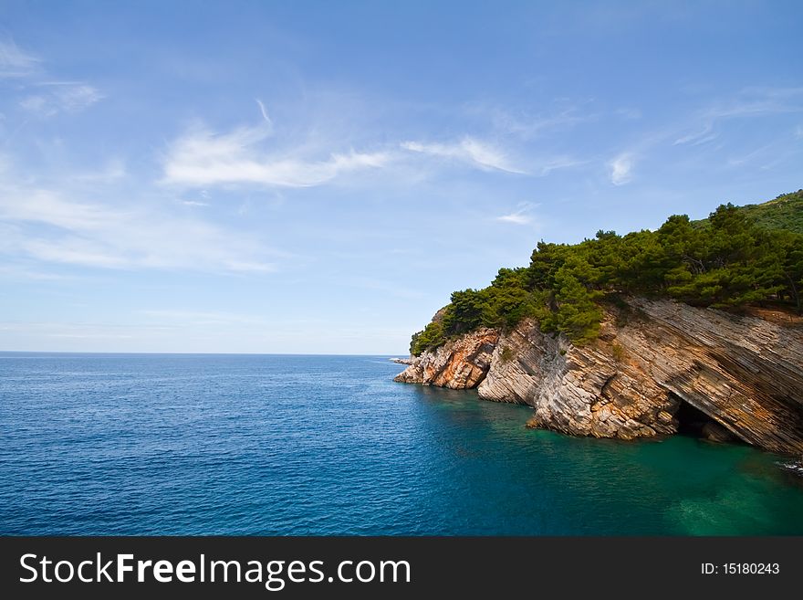 Pictorial blue Adriatic sea with rocks and trees