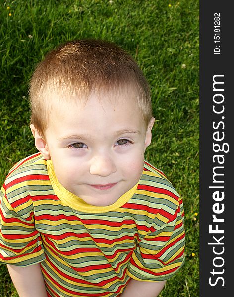 The child looks up, portrait, the background grass