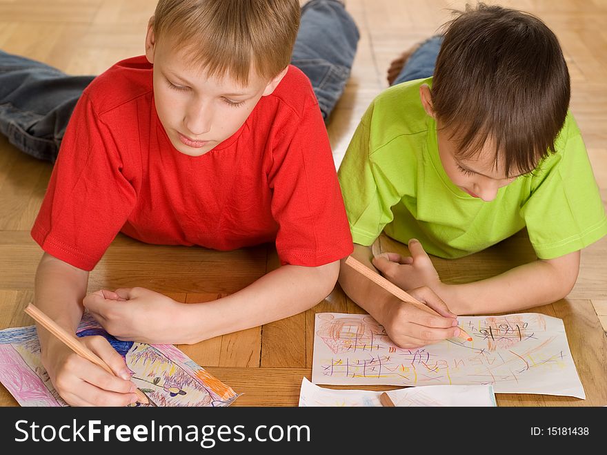 Two brothers lying on the floor and draw. Two brothers lying on the floor and draw