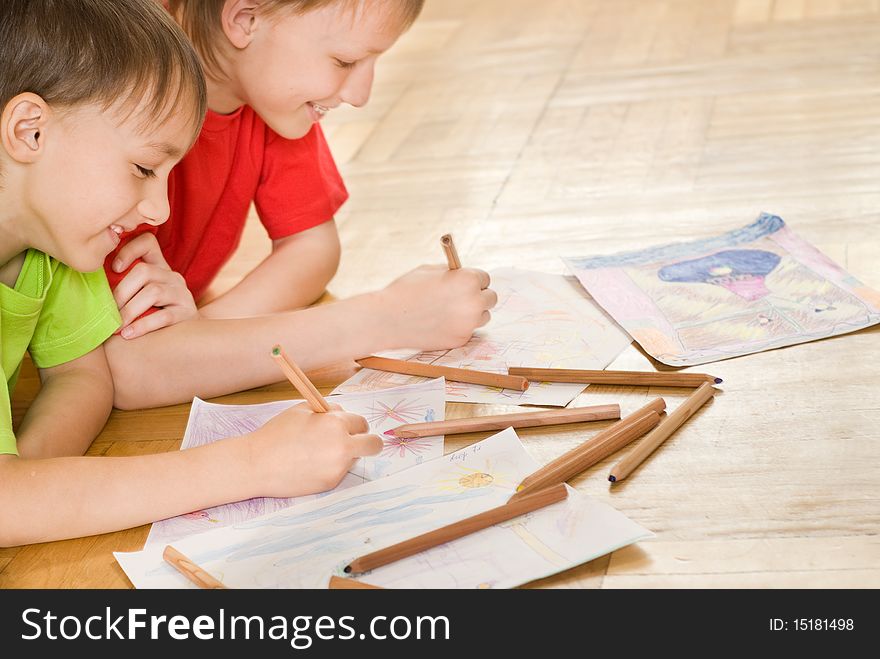 Two brothers lying on the floor and draw. Two brothers lying on the floor and draw