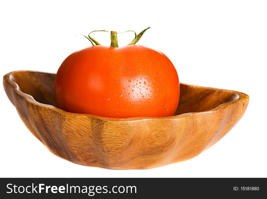 Tomato in wooden bowl isolated on white background