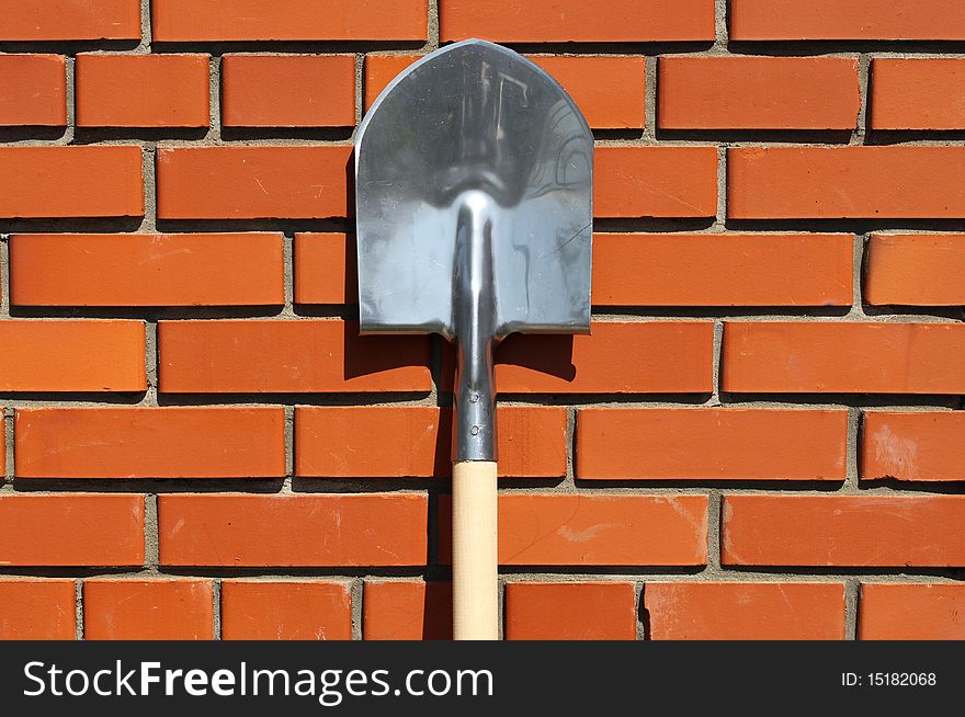 Spade standing at a wall in a garden