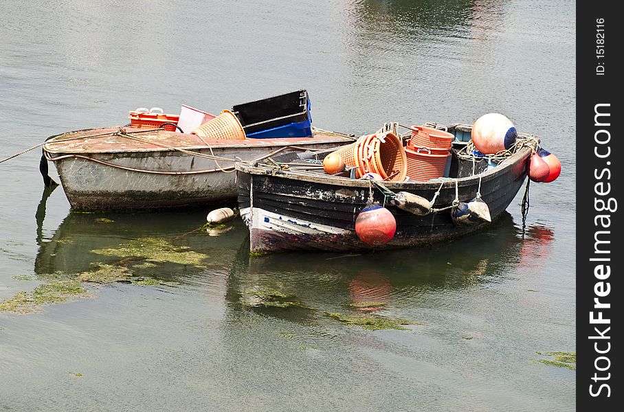 Two small wooden fishing boats in still waters