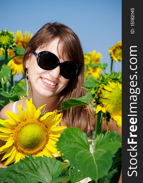 Young beautiful girl on a sunflower field in summer. Young beautiful girl on a sunflower field in summer