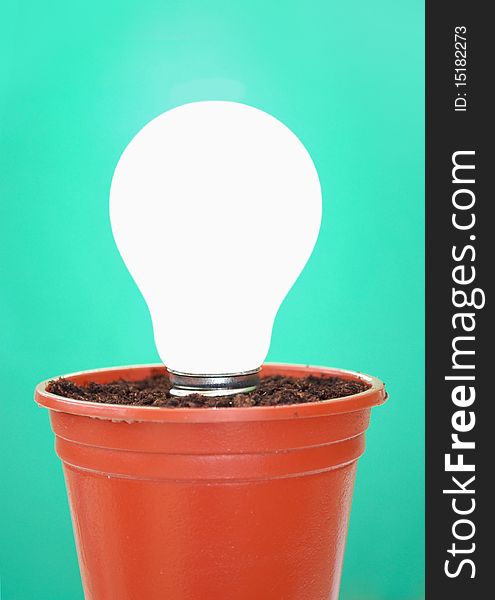 Lit light bulb in a pot with soil. Lit light bulb in a pot with soil