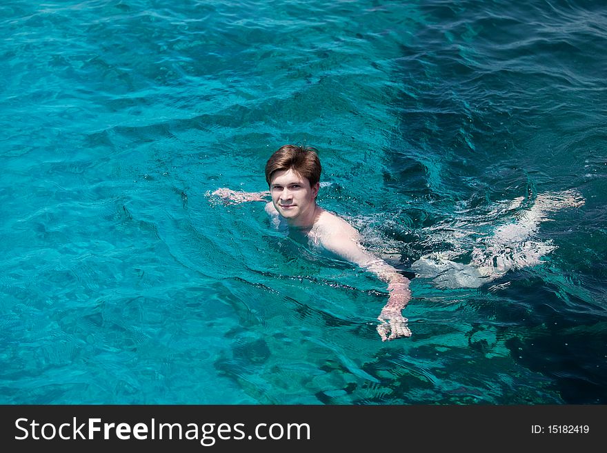 Young man swims in the sea.