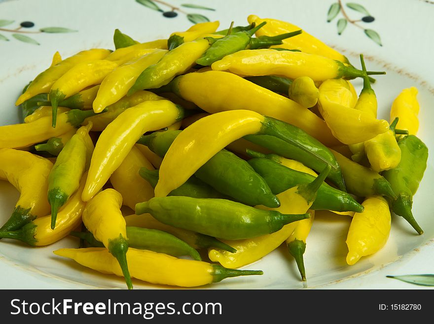 Green and yellow chilis on a plate