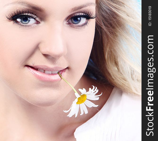 Close-up portrait of a fresh and beautiful woman with camomile.