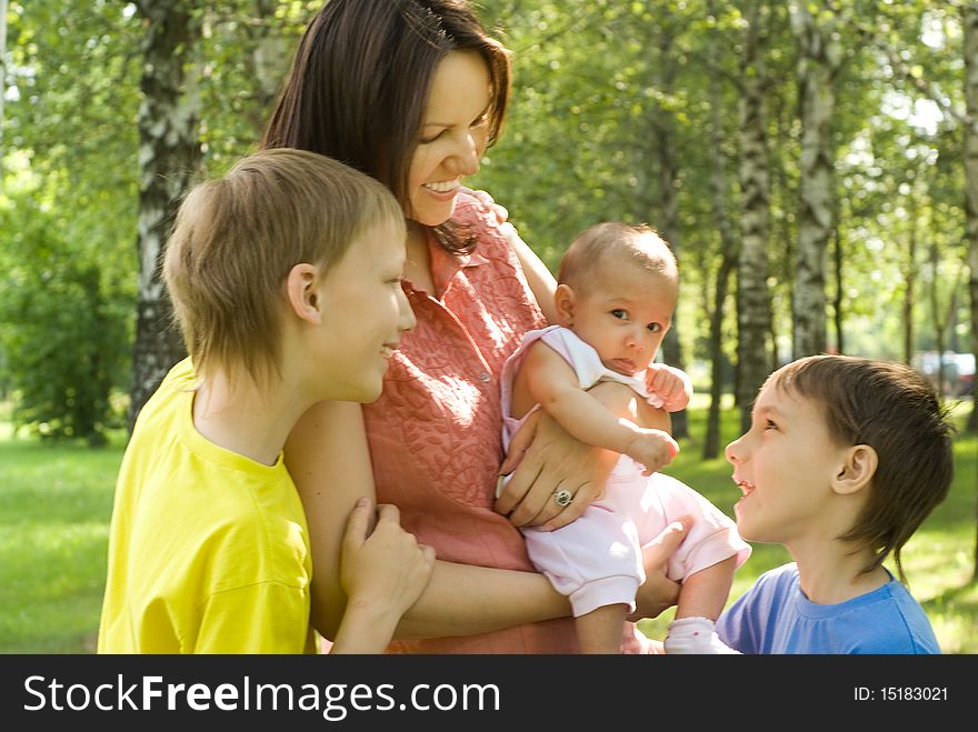 Happy boys with mom  in the summer park