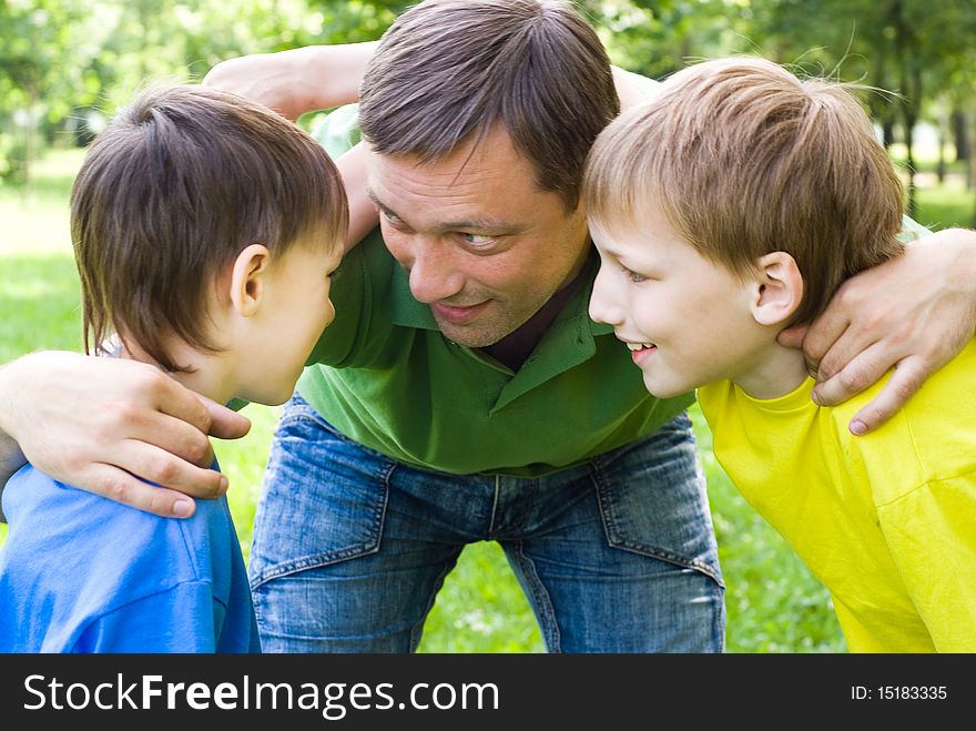 Dad plays with young children outdoors