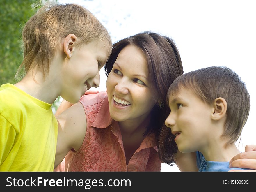 Happy boys with mom in the summer park