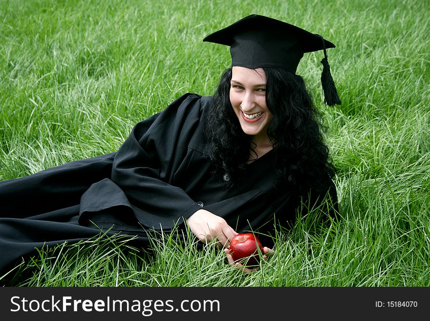 Young smiling caucasian student laying on the grass