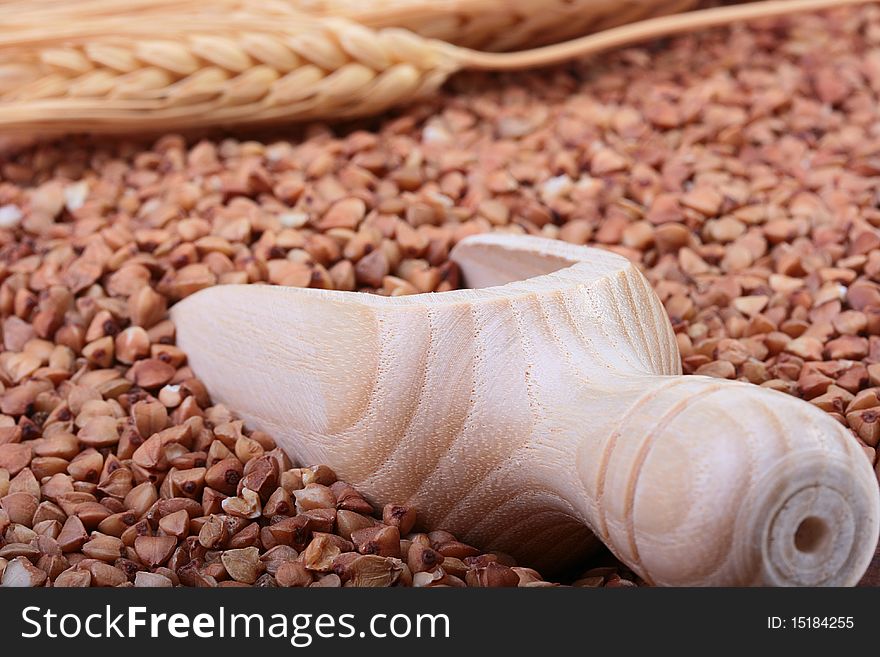 Buckwheat groats with a wooden deep spoon for packaging.