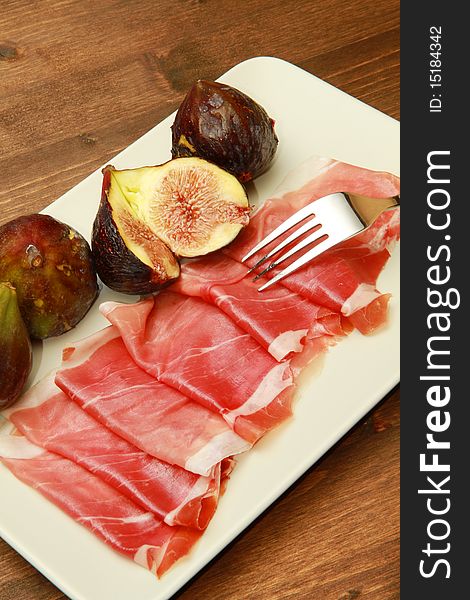 A dish with fresh fig with ham