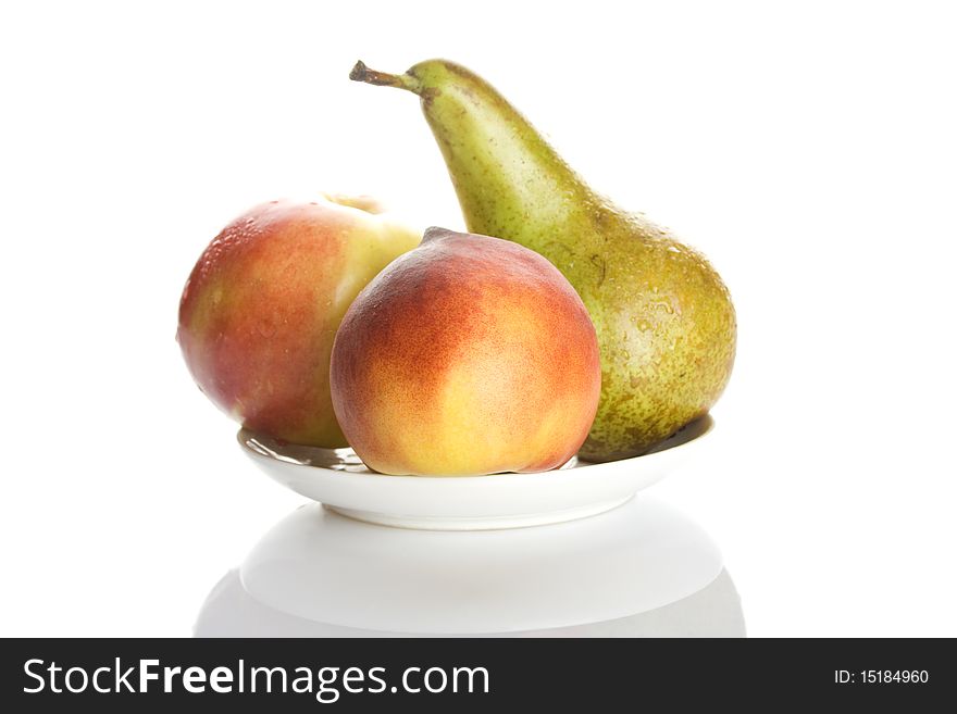 Fruit, peach pear and apple are on a white plate isolated on white background