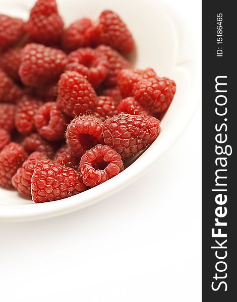Raspberries in a bowl against white background with plenty of copy space. Healthy eating concept. Raspberries in a bowl against white background with plenty of copy space. Healthy eating concept.