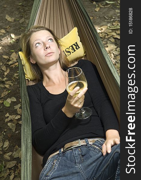 Beautiful girl in a hammock with wine