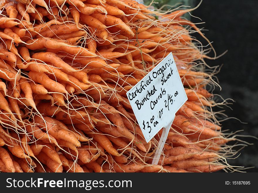 A mountain of fresh carrots at a farmer's market. A mountain of fresh carrots at a farmer's market.