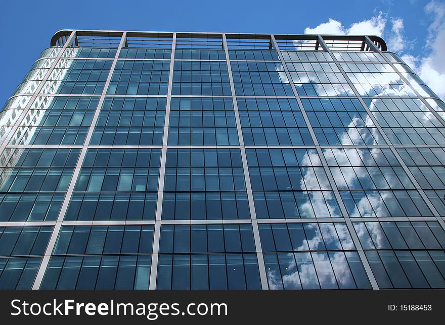 Cloud reflection in a skyscraper at Canary Wharf in London; contrast between architecture and weather