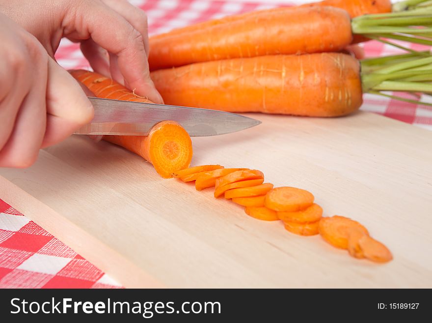 Chopping Carrots on Wooden Chopping Board. Chopping Carrots on Wooden Chopping Board