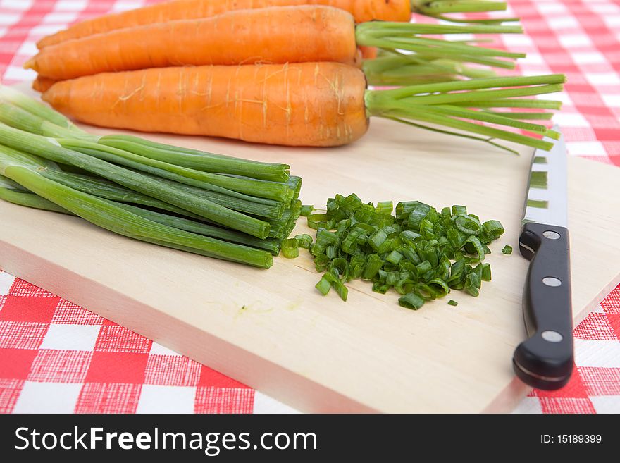 Chopped Spring Onion and Carrots on a Chopping Board. Chopped Spring Onion and Carrots on a Chopping Board