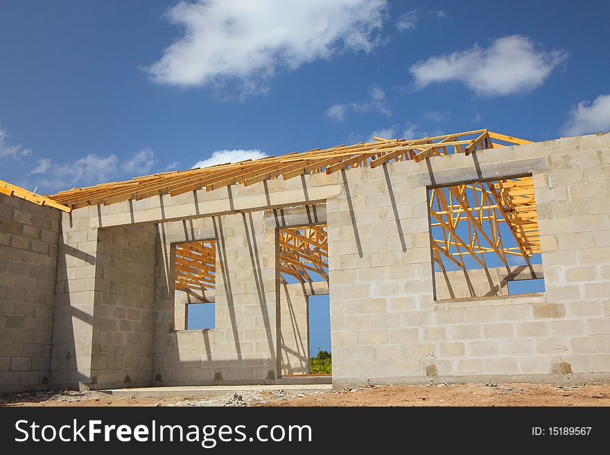 New Home Construction of a cement block home with wood roof trusses viewed from outside.