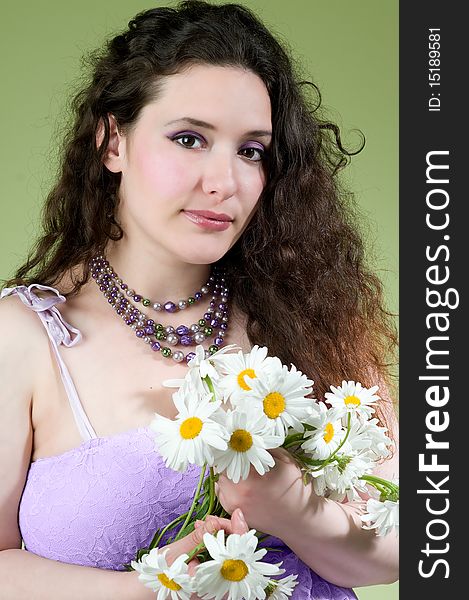 Beautiful young model wearing lacy lavender dress holding flowers. Beautiful young model wearing lacy lavender dress holding flowers