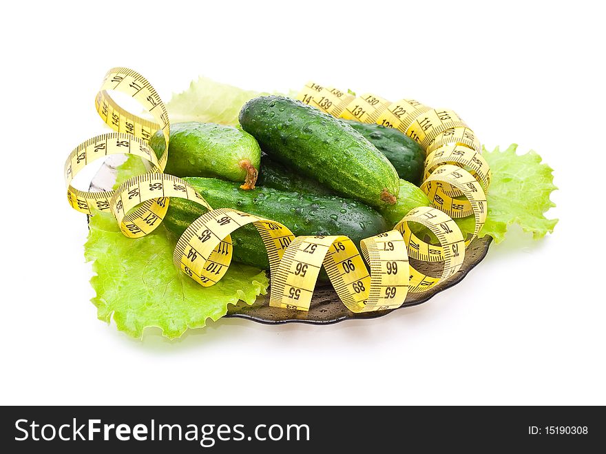 Cucumbers with a measuring tape on white