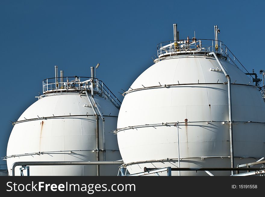 Two silos standing besides each other below a blue sky.