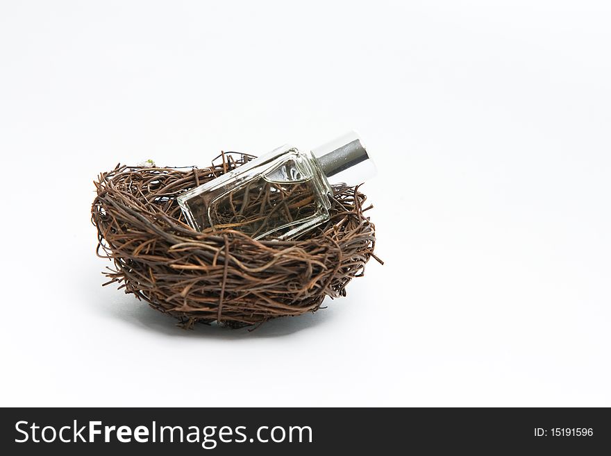 Fragrance bottle in a bird cage isolated on white. Fragrance bottle in a bird cage isolated on white