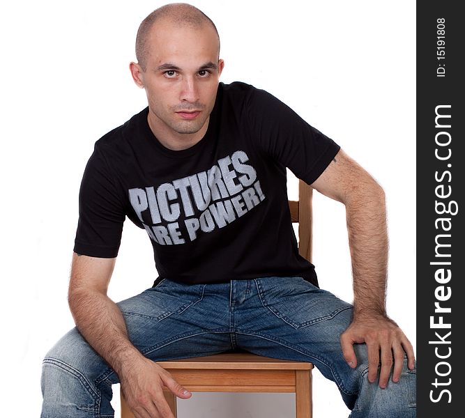A young bald Man sitting on a chair