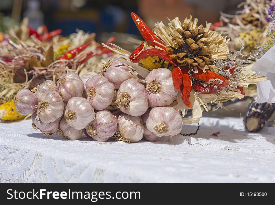 A ristra of garlic sits on a table at a local farmers market. A ristra of garlic sits on a table at a local farmers market
