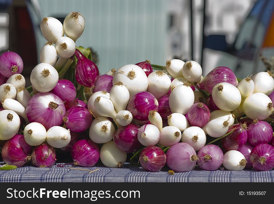 Onions sit on a table at a local farmers market. Onions sit on a table at a local farmers market