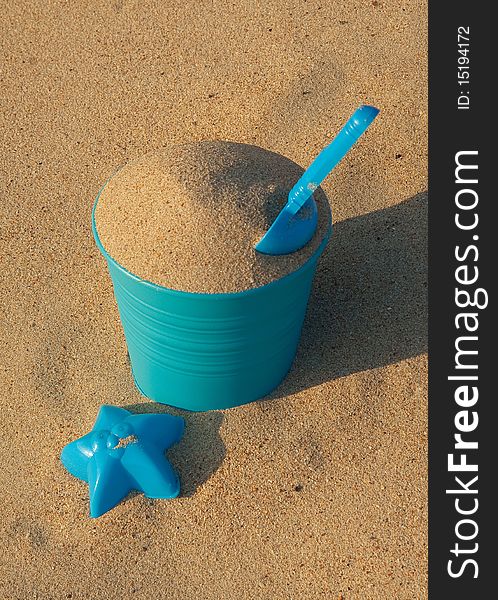 Bucket, shovel and shell shaped mould on the sand background. Bucket, shovel and shell shaped mould on the sand background