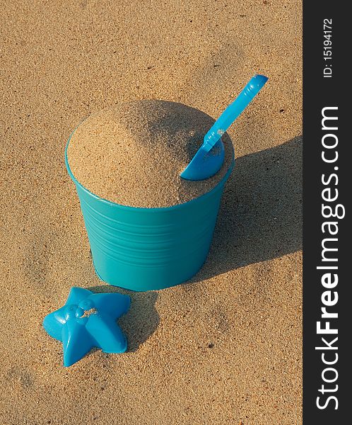 Blue plastic toys on the sandy beach