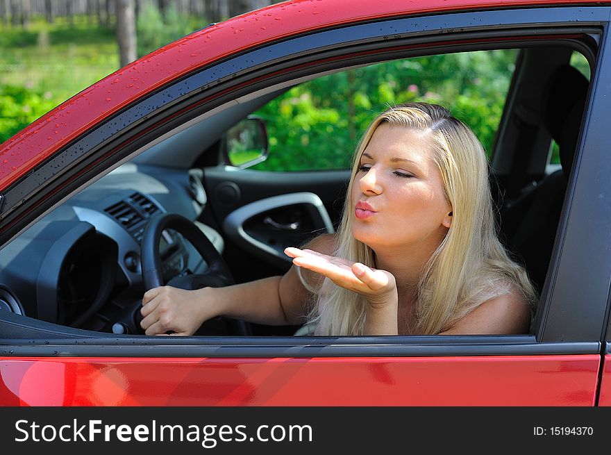 Beautiful Woman Driver In Red Shiny Car Outdoors